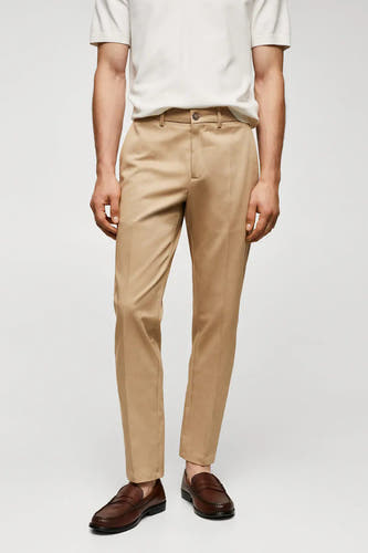 Chino marron de MANGO, associé à un t-shirt blanc et des loafers en cuir marron.