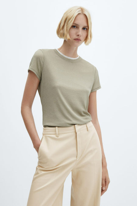 Pantalon beige de MANGO, tissu léger, coupe droite, modèle avec chemise verte, vue de face
