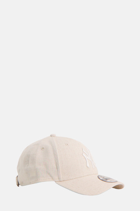 Chapeau beige de New Era avec logo brodé et fermeture ajustable, vue latérale.