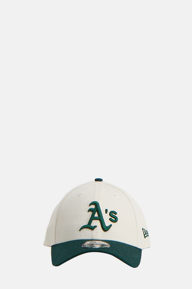Chapeau beige de NEW ERA, avec une languette verte et un logo.