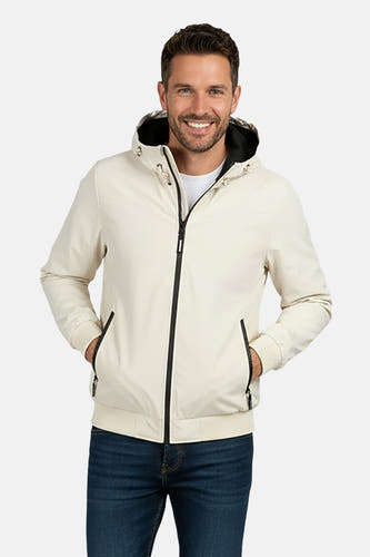Manteau court beige de Cars avec capuche et fermeture éclair noire porté sur une chemise blanche et un jean.