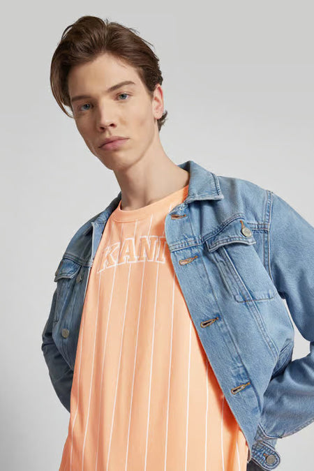 T-shirt orange à manches courtes de Karl Kani, avec des rayures verticales blanches et une veste en denim.