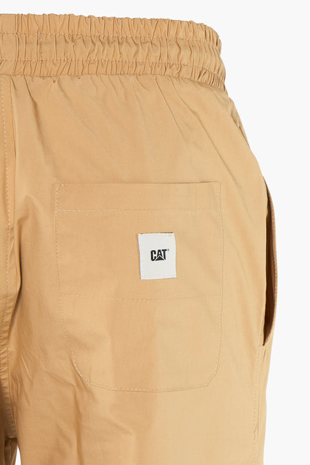 Pantalon beige de CATERPILLAR, avec poche arrière et ceinture élastique, sur un fond blanc.