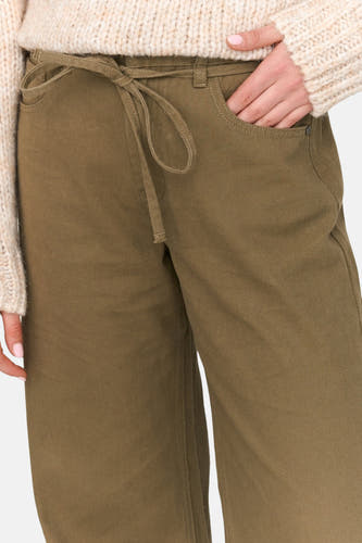 Pantalon vert de 24 Colors GMBH, avec détail rayé et poche à monnaie, combiné à une veste tricotée.