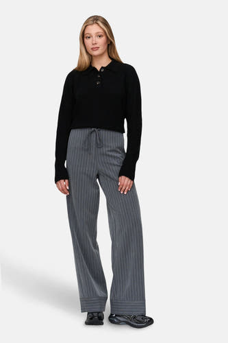 Pantalon gris de 24 colours gmbh, avec une bande de craie et des jambes larges, associé à un pull noir.