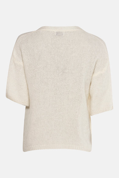 Cardigan blanc de Terra di Siena, texture tricotée et manches courtes.