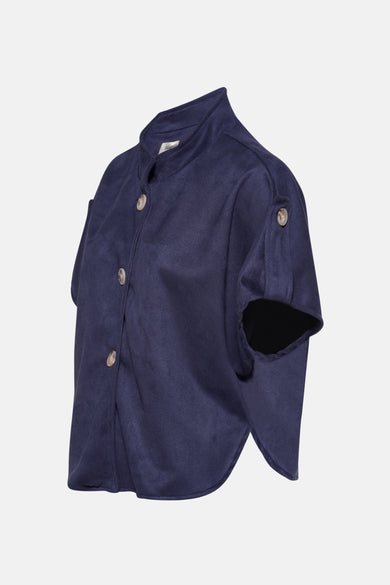 Gilet bleu de Terra di Siena avec col montant, manches courtes amples, boutons clairs et tissu aspect daim sur les côtés.