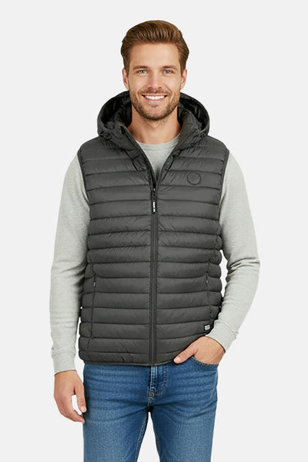 Kakikleurige bodywarmer van Cars met capuchon, gedragen over een grijze trui en blauwe jeans.