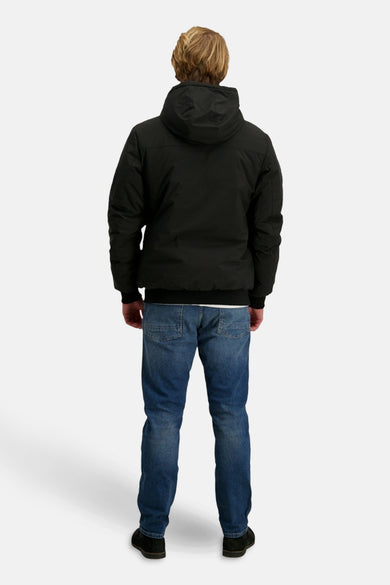 Manteau court noir de Cars, avec capuche, porté avec des jeans bleus et des chaussures noires, vue arrière.