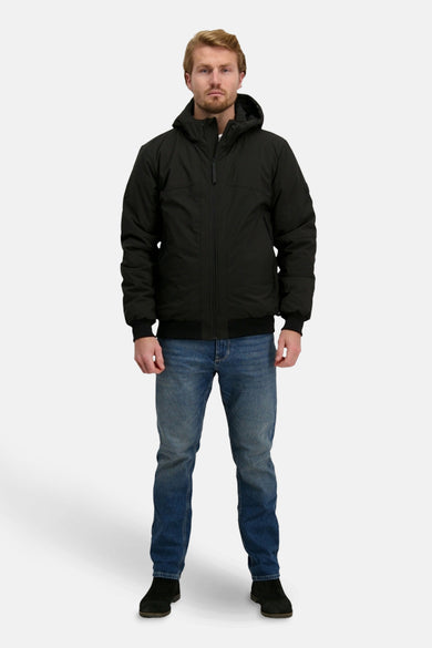 Manteau court noir de Cars, porté avec un pantalon en cuir et des chaussures noires.