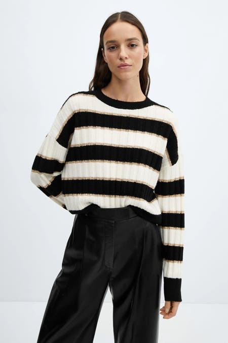 Pull à rayures noires et blanches avec col rond de MANGO, avec des détails blancs et dorés et des manches longues.