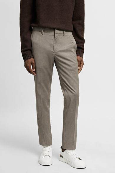 Bruine trui, geruite pantalon, witte sneakers.
