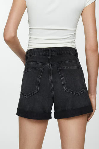 Short de denim noir de MANGO, vu de de l'arrière avec des poches rabattues, associé à un t-shirt blanc.