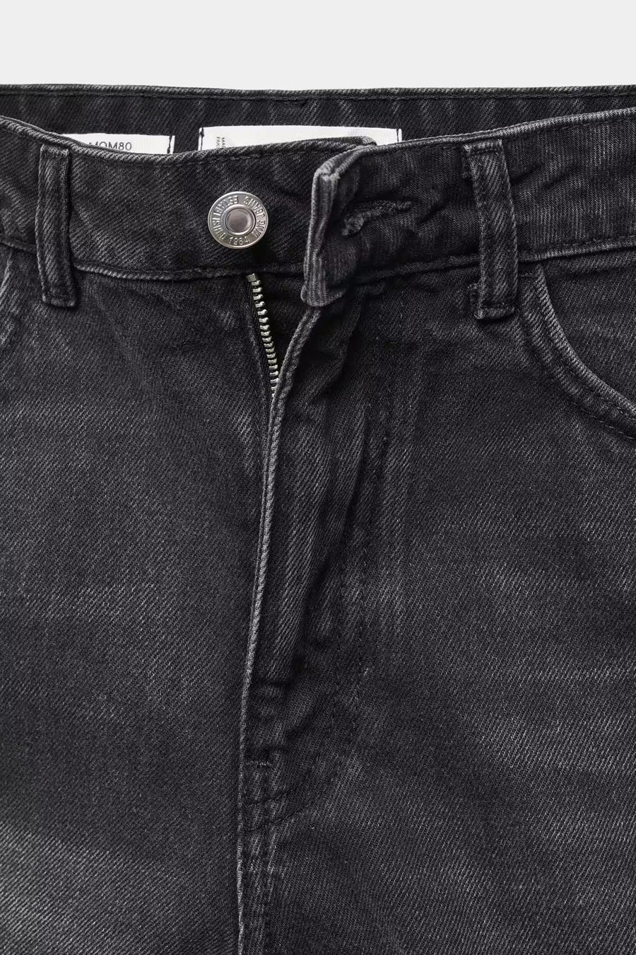 Short en denim noir de MANGO avec une fermeture éclair et un détail de nœud métallique.