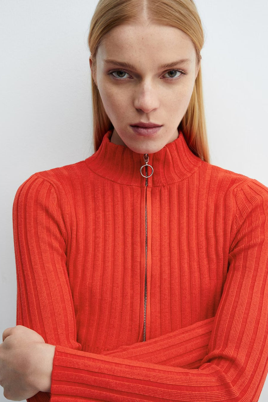 Gilet rouge de MANGO avec des manches longues, une texture côtelée et une fermeture éclair argentée.