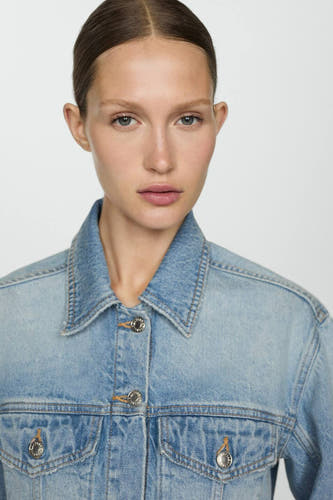 Jean en denim bleu mid de MANGO, avec des boutons argentés et des poches avant.