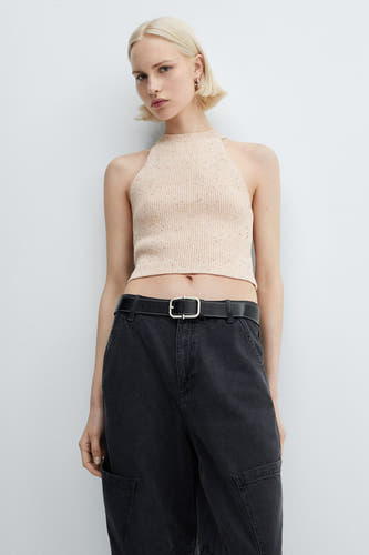 T-shirt rose de MANGO, porté avec un pantalon noir à cece et de grandes poches.