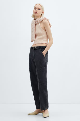T-shirt rose de MANGO, associé à un foulard décontracté, une jupe noire avec ceinture et des chaussures beige.