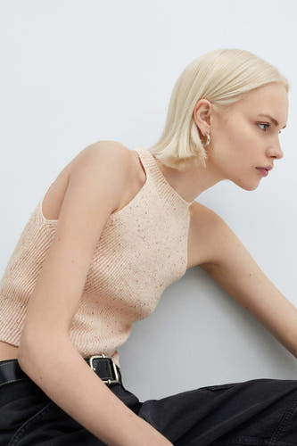 Maillot de corps rose de MANGO, avec une texture côtelée, associé à un pantalon noir et à une ceinture.
