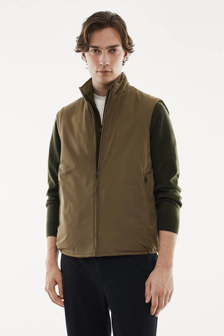 Gilet vert de MANGO, porté sur une chemise verte foncée et associé à un pantalon noir.