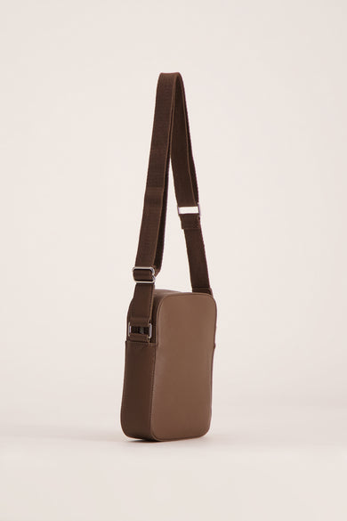Sac à dos marron de MANGO, avec une sangle d'épaule en toile et des détails métalliques argentés, en position verticale.