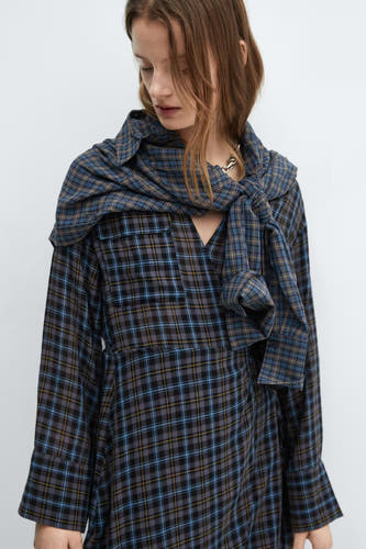 Robe bleue à longues manches de MANGO, avec un motif rayé et un foulard noué sur les épaules.
