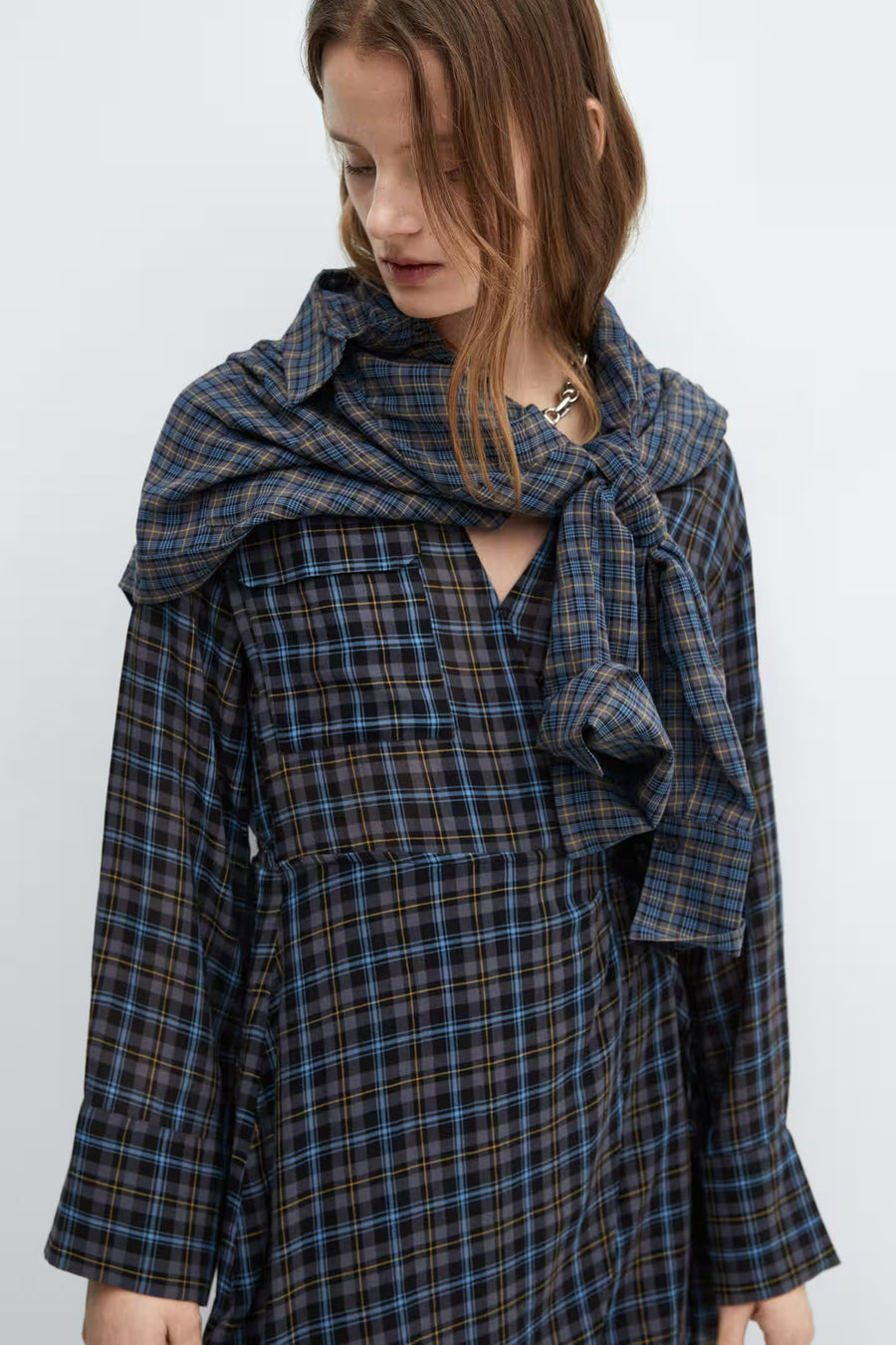 Robe bleue à longues manches de MANGO, avec un motif rayé et un foulard noué sur les épaules.