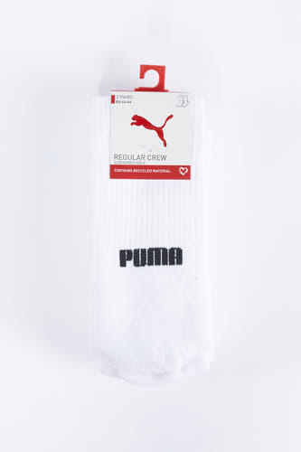 Chaussettes blanches de PUMA, avec le nom de marque noir dessus, emballées avec un étiquette cartonnée et un cintre.