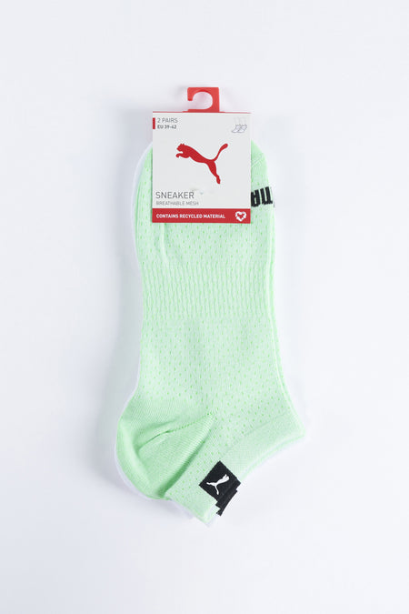 Chaussettes vertes de PUMA, avec un motif de petits trous et un logo noir.