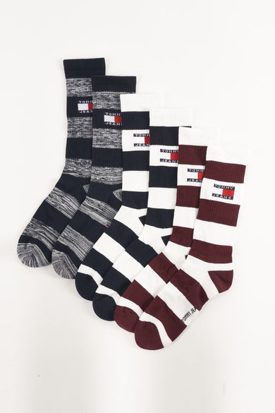 Chaussettes bleues de TOMMY JEANS, rayées et avec logo sur un fond blanc.
