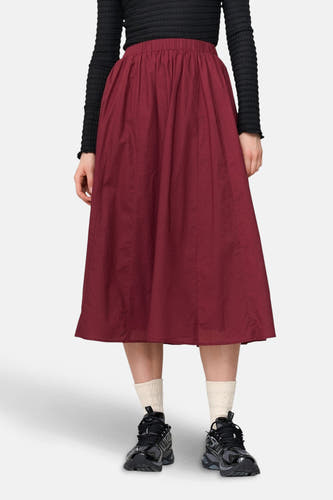 Robe de Bordeaux de 24 couleurs GmbH, associée à un t-shirt noir à longues manches, des chaussettes blanches et des chaussures noires.