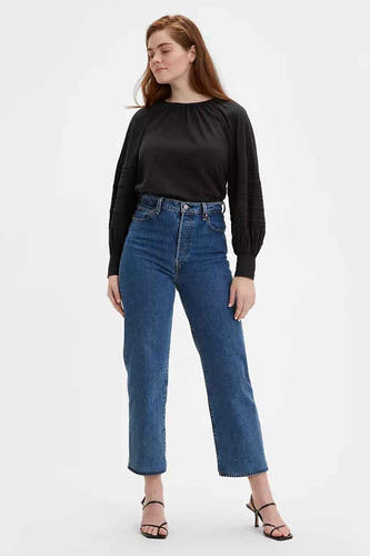 Jean droit en denim bleu moyen de Levi's, associé à un chemisier noir et des talons.