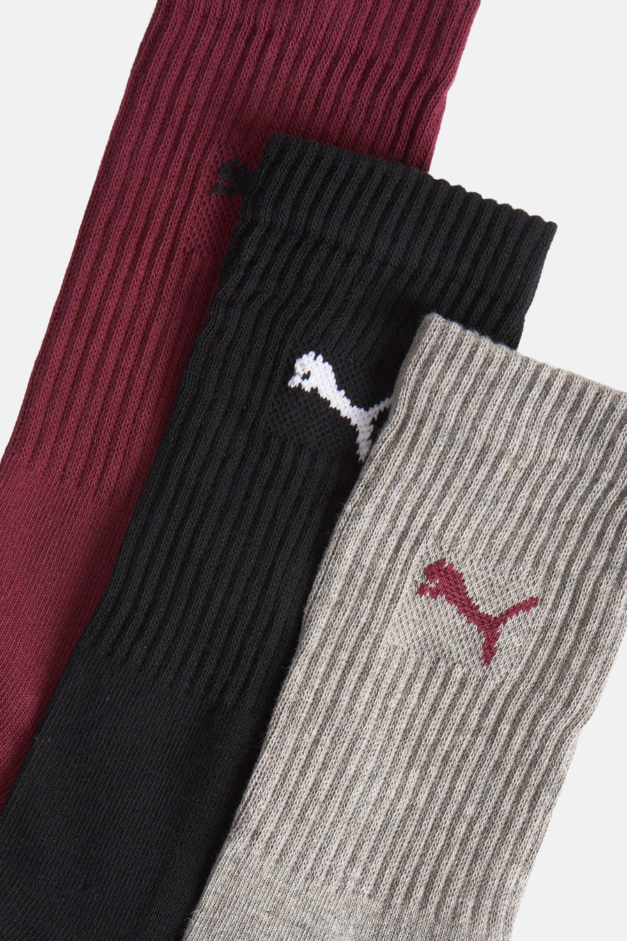 Chaussettes multicolores de PUMA, avec une texture rayée et un logo brodé dans différentes couleurs.