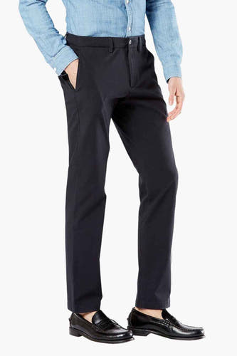 Blauwe chino van DOCKERS, gecombineerd met een lichtblauw overhemd en zwarte loafers.