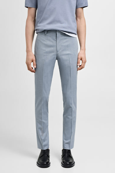 Pantalon de costume bleu MANGO, avec des plis et des chaussures en cuir noir.