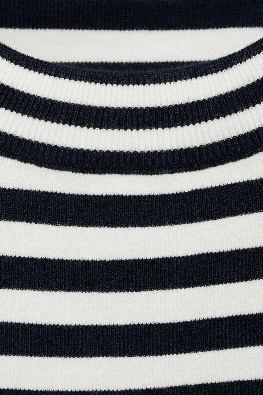 Close-up van een gestreepte trui in marineblauw en wit.
