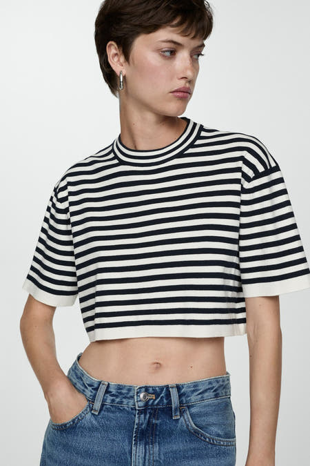 Marinière bleue à rayures de MANGO avec col rond, portée avec un jeans bleu à taille haute.