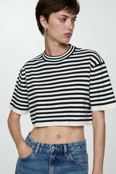 Marinière bleue à rayures de MANGO avec col rond, portée avec un jeans bleu à taille haute.