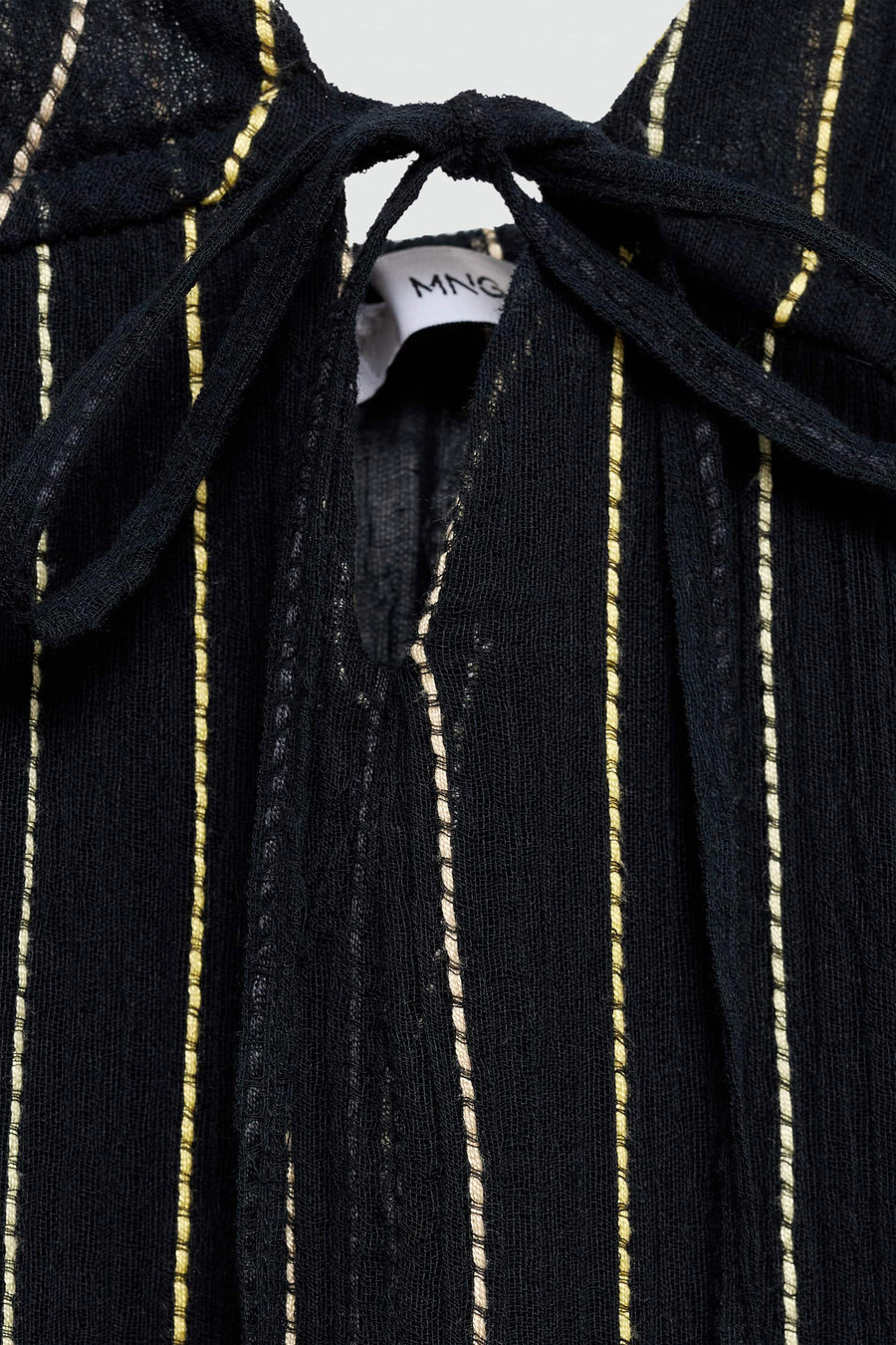 Zwarte, gestreepte top met knoopdetail.