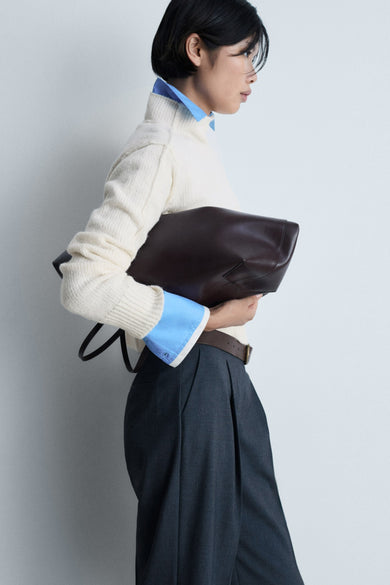 T-shirt blanc à col rond de MANGO, porté avec un chemisier bleu et un pantalon large, vue arrière.
