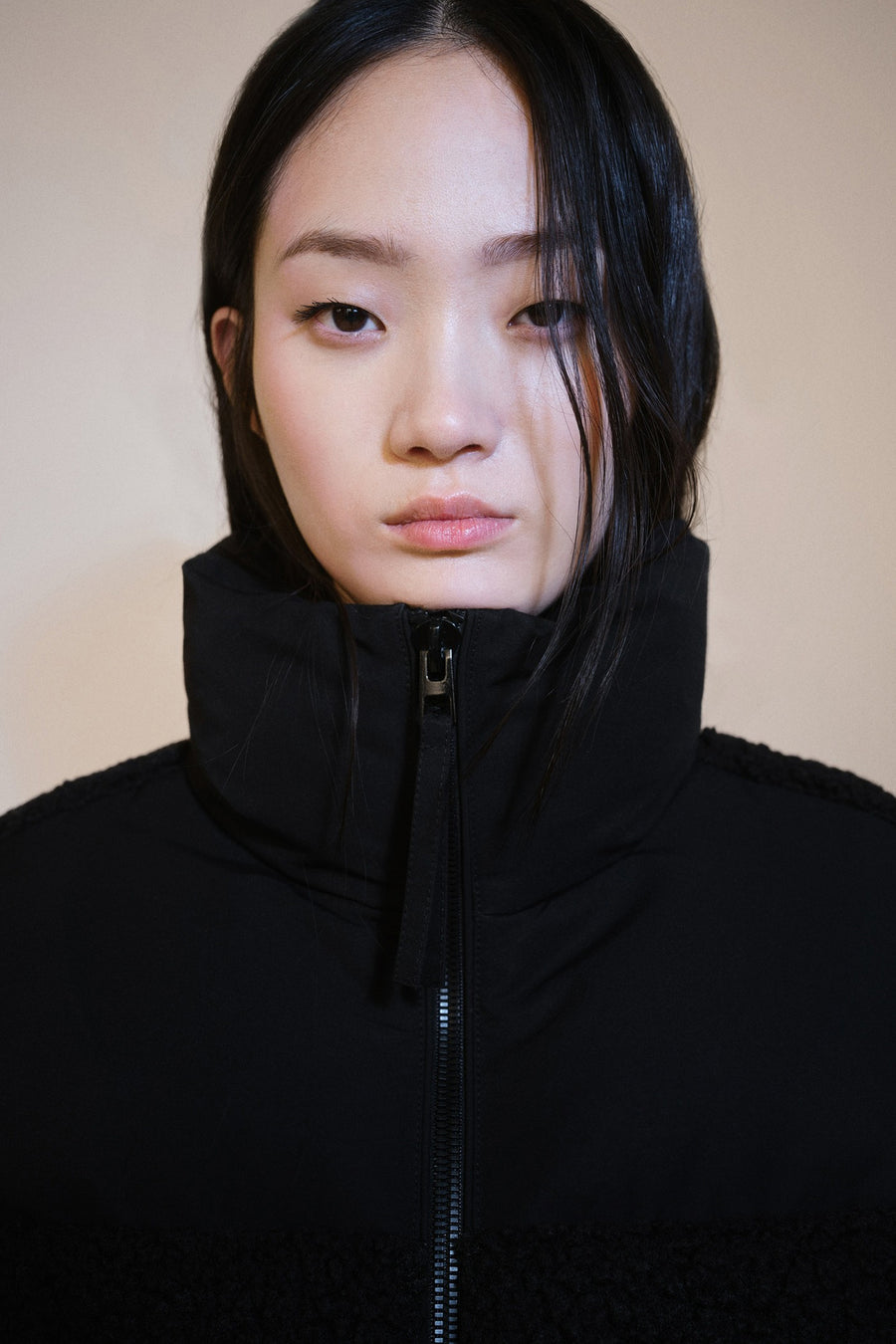 Manteau court noir de MANGO avec un col haut et une fermeture éclair à l'avant.