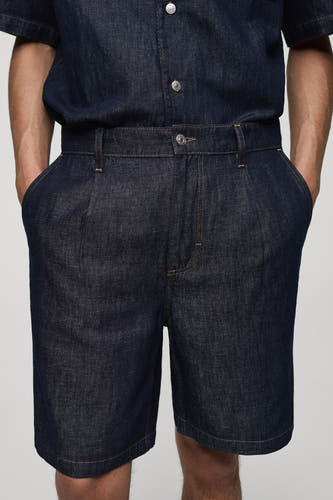 Jean en denim court de MANGO, réalisé en denim bleu moyen avec des plis et des poches.