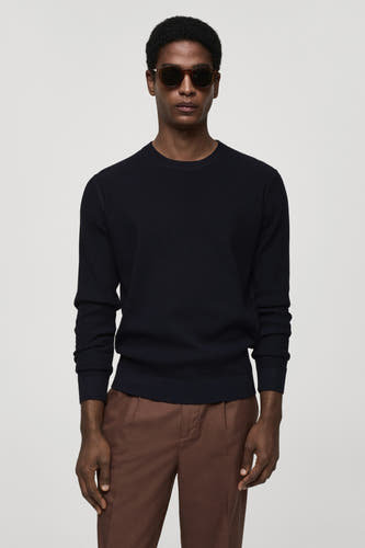 T-shirt bleu avec col rond de MANGO, texture rayée sur le dos, associé à un pantalon marron.