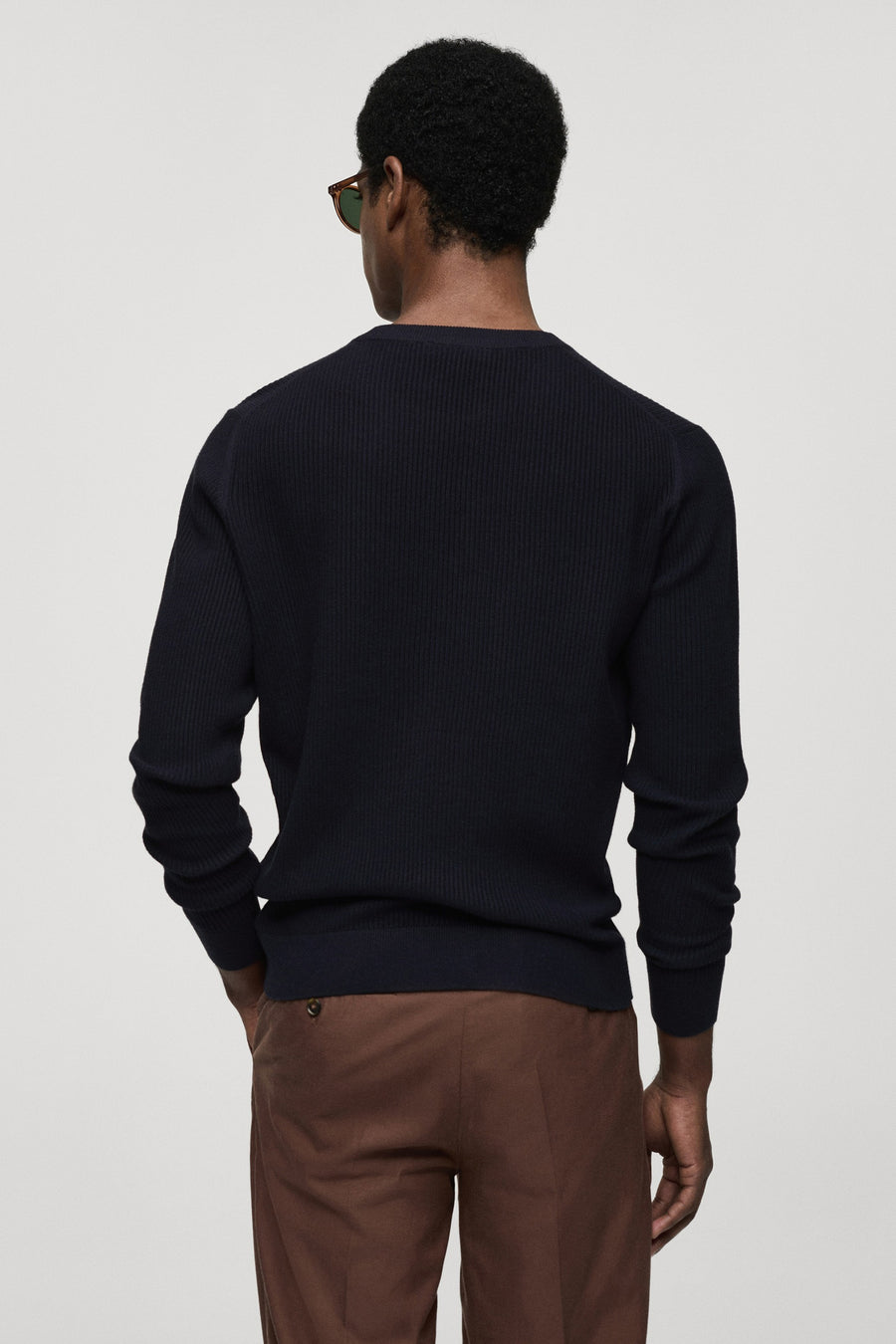 Blauwe trui met ronde hals van MANGO, geribbelde textuur op de rug, gecombineerd met bruine broek.