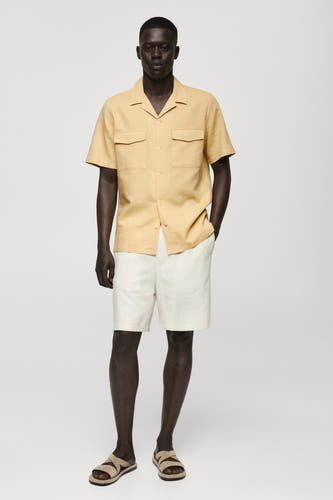Chemise jaune à manches courtes de MANGO, avec deux poches et un col ouvert.