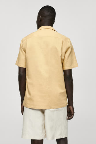 Geel overhemd met korte mouwen van MANGO, gezien van achteren, gedragen met witte shorts.