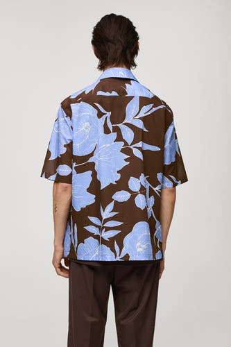 Chemise à fleurs brune de MANGO, vue de derrière, associée à un pantalon brun.