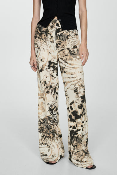 Pantalon beige de MANGO avec une imprimé d'animal et des jambes larges, associé à un haut noir.