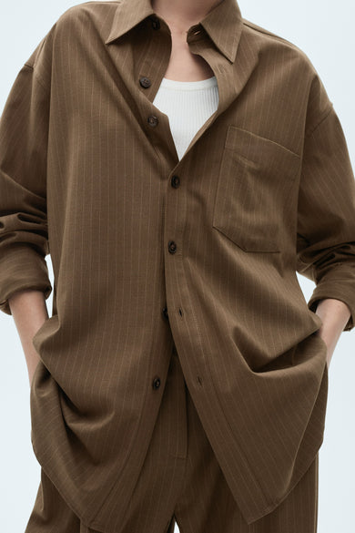 Blazer brun oversized de MANGO, avec un motif à carreaux et des manches longues, vu sur le dos.