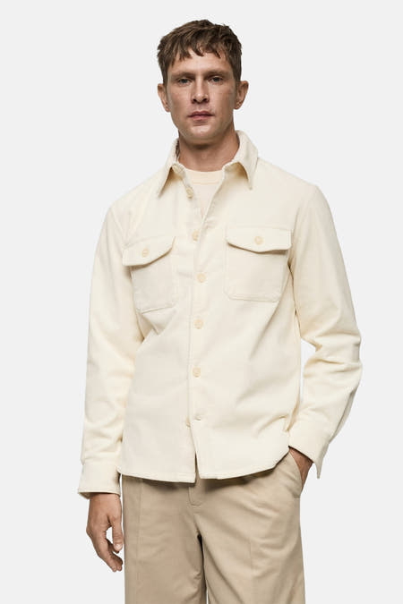 Chemise blanche à manches longues de MANGO, texture corduroy lisse, vue sur le dos d'un homme.